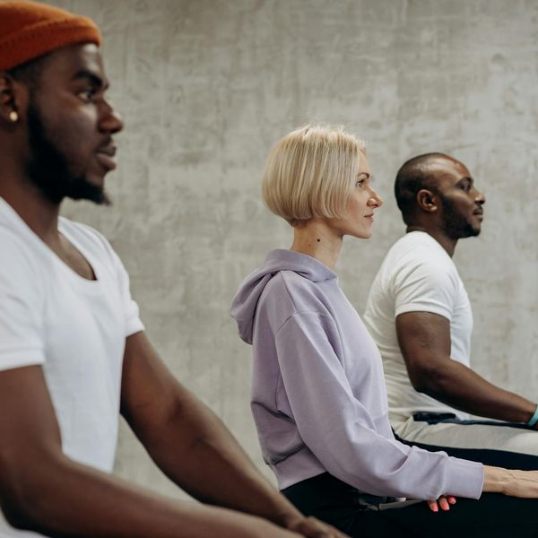 A diverse group of people sitting in a calm meditation circle.